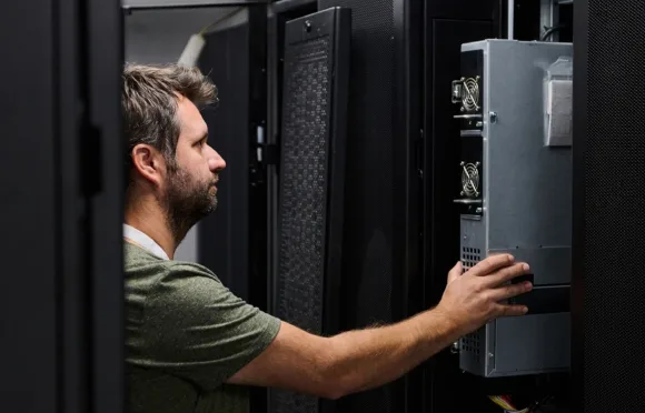 Technician inspecting UPS monitoring equipment